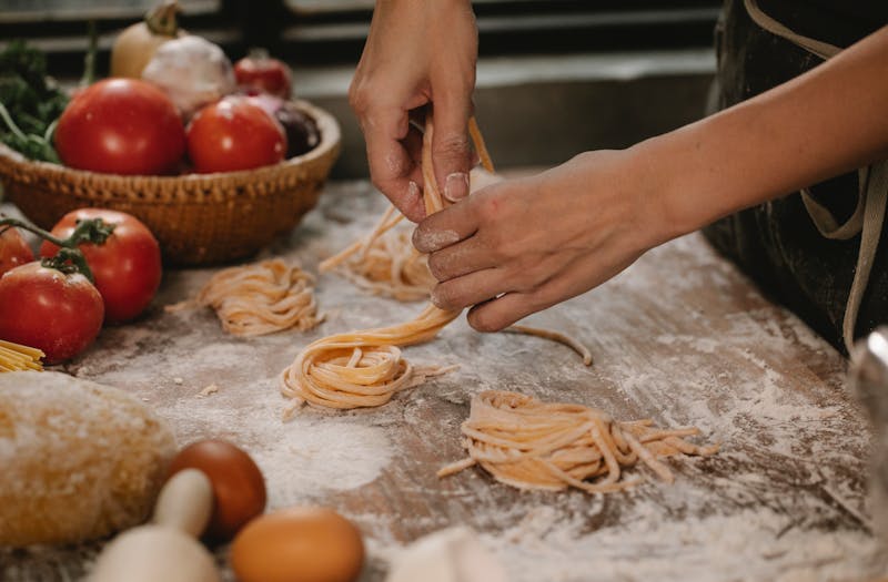 Chef hand-stretching fresh Neapolitan pizza dough